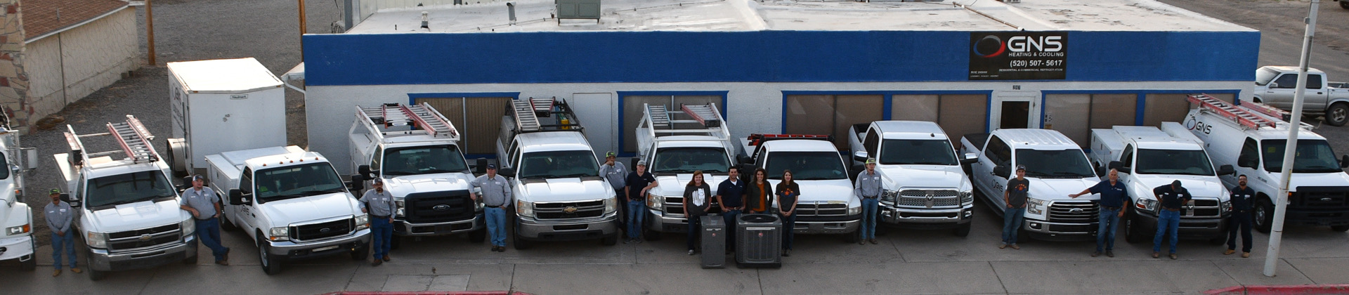 The GNS crew stands with their service trucks in front of the GNS shop.